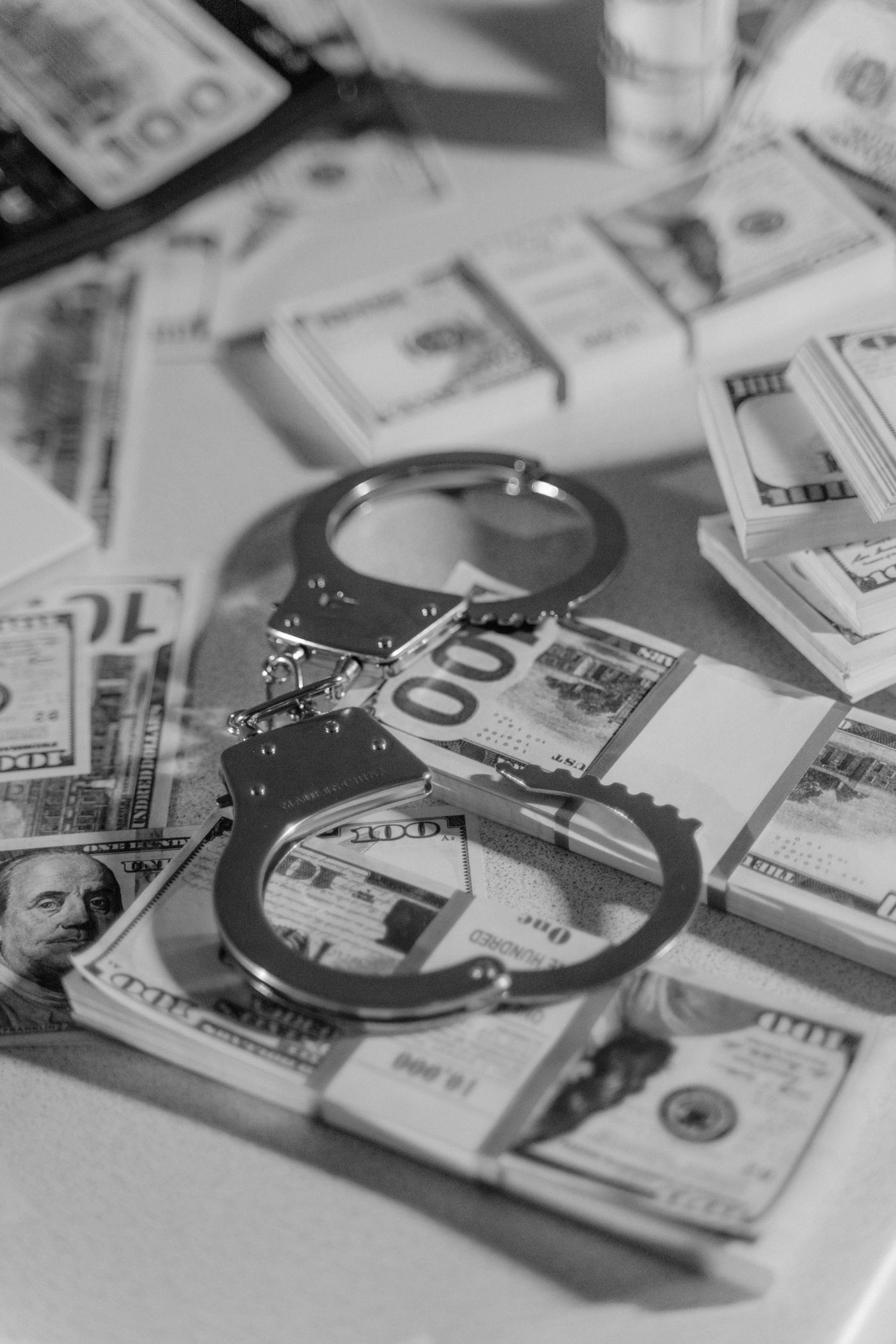 Handcuffs resting on stacks of cash