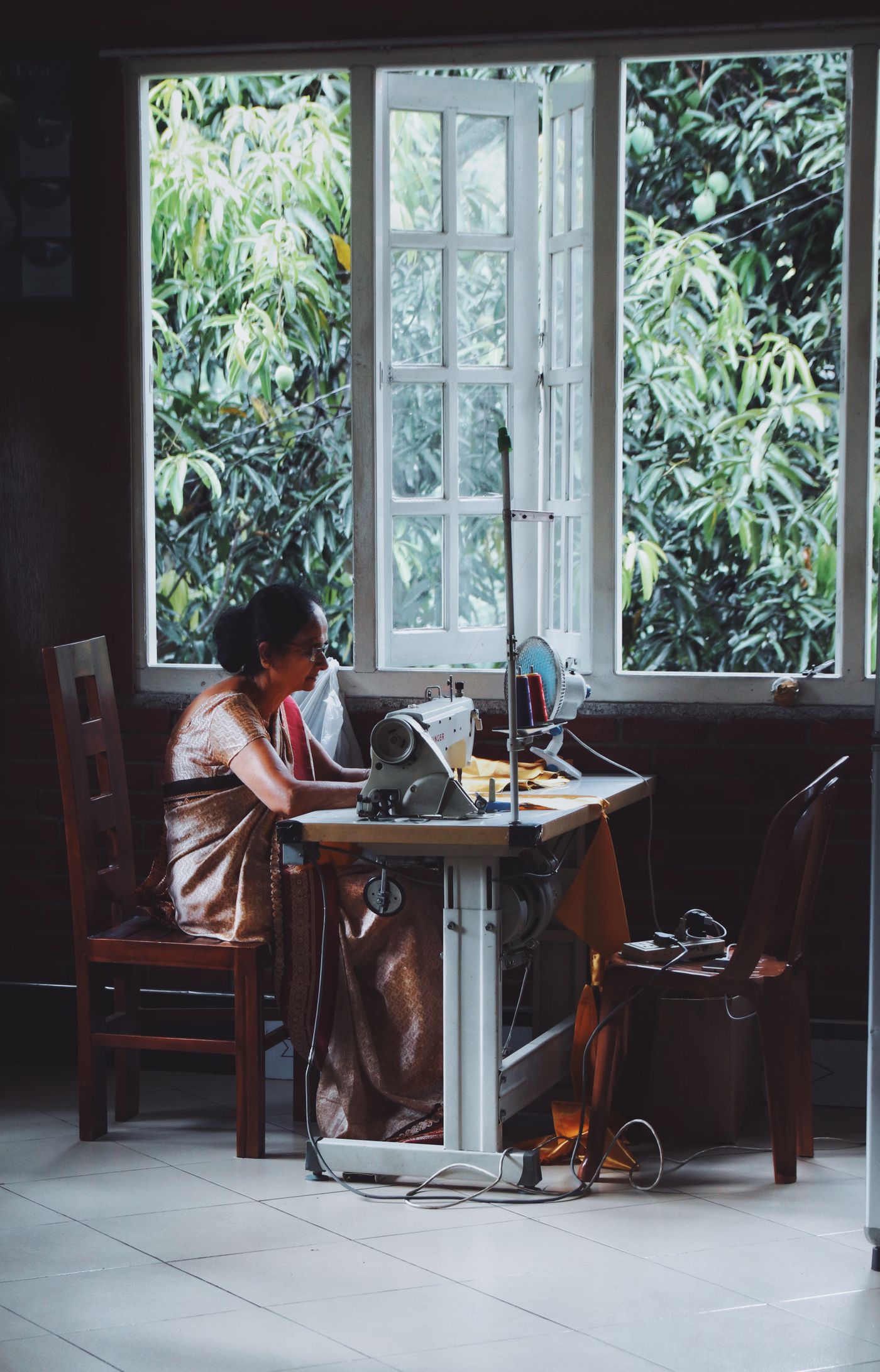 Indian woman working at her own sewing machine